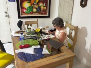 Naomi painting at the kitchen table